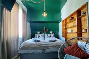 una camera verde con un letto e due sedie di The perfect stop - 3rd floor & Lodge a Lødingen