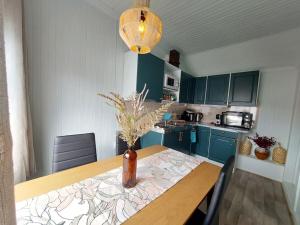 una cucina con tavolo in legno e vaso; di The perfect stop - 3rd floor & Lodge a Lødingen