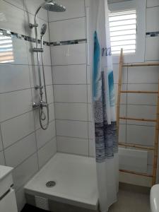 a bathroom with a shower with a shower curtain at Edith, T2 design plage Gros-Raisins Sainte-Luce in Sainte-Luce