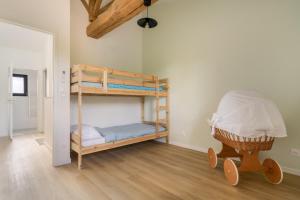 a bedroom with bunk beds in a room with wooden floors at La maison du Sophora grande maison 3 chambres in Saint-Didier-de-Formans