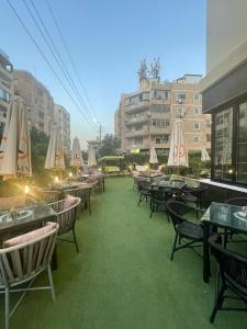 カイロにあるEl Mesaadya Hotel فندق المساعديةのパティオ(パラソル付きのテーブルと椅子付)