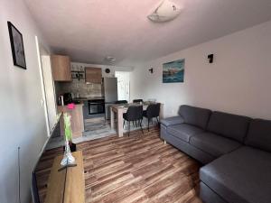 a living room with a couch and a kitchen at Apartment Žega in Kaštela