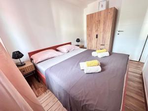 a bedroom with a large bed with towels on it at Apartment Žega in Kaštela