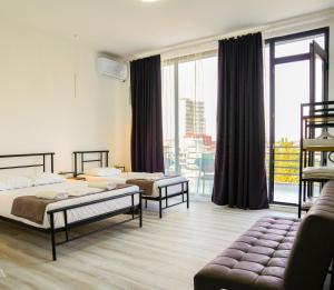 una camera d'albergo con due letti e un balcone di Hotel General Tso Kobuleti a Kobuleti