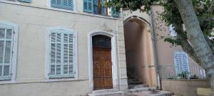 un edificio con una puerta de madera y un árbol en Studio hypercentre, refait à neuf, en Aubagne