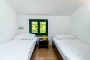 two beds in a room with a window at HAUS RITA in Labin