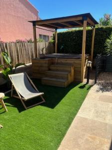 a garden with a gazebo and a chair on grass at Appartement Vacances ZEN in Fréjus +3 photos
