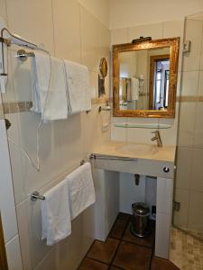 ein Badezimmer mit Waschbecken, Spiegel und Handtüchern in der Unterkunft Backsteinparadies in Lüneburg + 13 Fotos