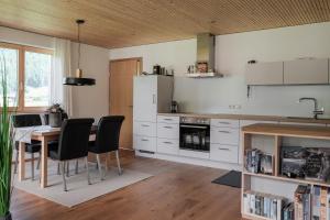 a kitchen with white cabinets and a table with chairs at 751Pelzrain in Bezau