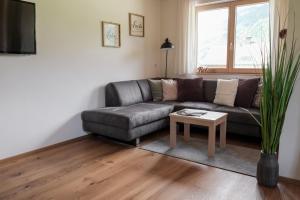 a living room with a leather couch and a table at 751Pelzrain in Bezau