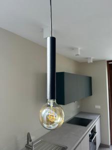 Una cocina con una luz auxiliar colgando sobre una encimera. en Simply Deux, en Stavelot