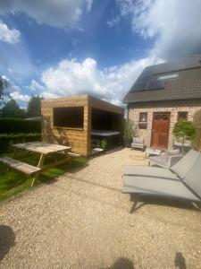 a house with a picnic table and a couch at Mon petit cocon in Jalhay