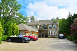 a house with three cars parked in a driveway at Explorer House Bed & Breakfast in Niagara on the Lake