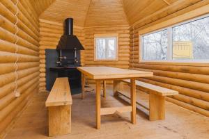 a wooden cabin with a table and benches in it at Ladoga Hotel in Petrozavodsk