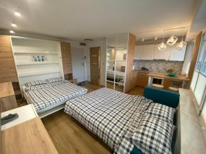 a small room with two beds and a kitchen at DiM Suwałki Pułaskiego in Suwałki