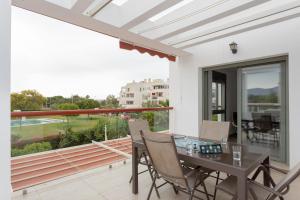 a dining room with a table and chairs on a balcony at Apto ATENAS, Retamar, Cabo de Gata in Almería