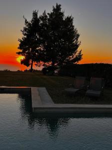 two chairs sitting next to a pool of water with a tree at Sunset Villa Elani in Elani