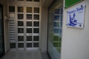 a sign on the side of a building with a door at Venezia e Terme in Montegrotto Terme