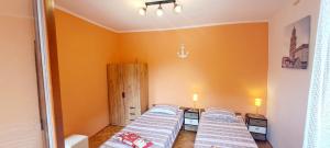 three beds in a room with orange walls at Dignano in Vodnjan