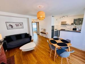 a living room with a couch and a table and chairs at Honoriane - Appartements meublés in Gien