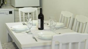 a white table with white plates and a bottle of wine at Vila Tamara 2024 in Žabljak +13 photos