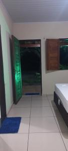 a room with a green door and a white tile floor at Chalé Renilton Turismo in Santo Amaro