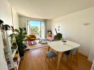 a living room with a table and chairs and a window at cozy two bed room flat near Champs-Élysée in Rueil-Malmaison