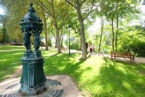 a green statue in a park with a bench at cozy two bed room flat near Champs-Élysée in Rueil-Malmaison +8 photos