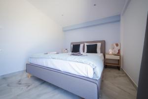 a bedroom with a bed with white sheets and pillows at Armonia House in Dhíkella
