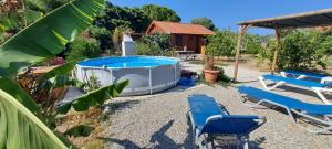 a backyard with a hot tub and two blue lounge chairs at Villa Soroni in Soroni