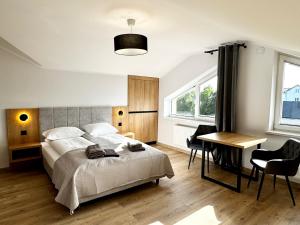 Un dormitorio con una cama, un escritorio y una mesa. en Apartamenty Flauta, en Jastrzębia Góra