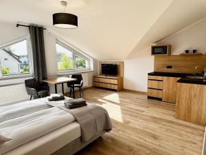 Un dormitorio con una cama y una cocina con una mesa. en Apartamenty Flauta, en Jastrzębia Góra