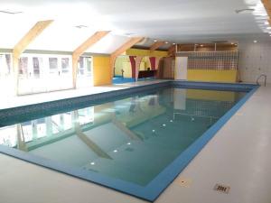 a swimming pool in a building with the water in it at 't Grote Egeltje XL chalet 220 in Durbuy