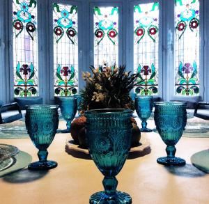 una mesa con jarrones de cristal azul y vidrieras en Casa del Mediterraneo, en Barcelona
