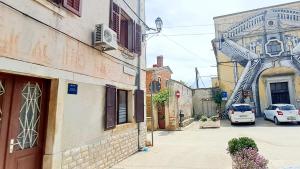 an alley with cars parked on the side of a building at Dignano in Vodnjan