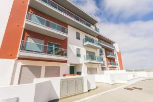 un edificio de apartamentos con una valla delante en Lovely & New BEACH APARTMENT, en Atouguia da Baleia