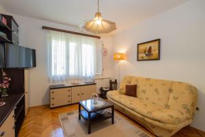 a living room with a couch and a table at Apartments ANIMA ex Marin in Podstrana