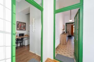a hallway with a green door and a table at Noble 5 star House in Unirii plaza in Cluj-Napoca