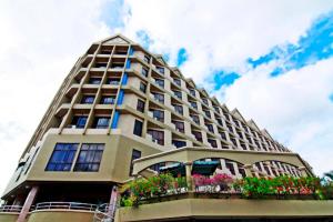 a tall building with flowers on a balcony at Hotel Grand Continental Langkawi in Kuah