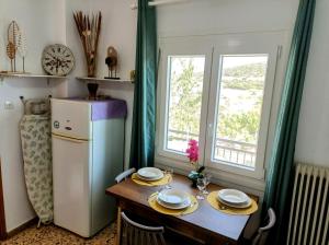 a small kitchen with a table and a refrigerator at Sunny Day Studios in Skala Marion