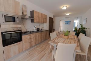eine Küche mit einem Holztisch und einem Tisch und Stühlen in der Unterkunft Brand new Apartament in Marsalforn in Żebbuġ