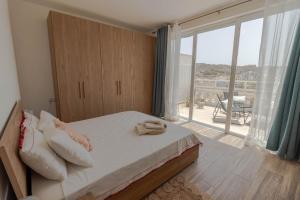ein Schlafzimmer mit einem Bett und einem großen Fenster in der Unterkunft Brand new Apartament in Marsalforn in Żebbuġ