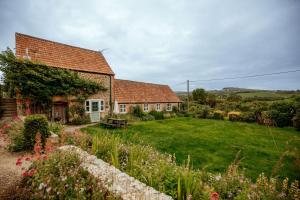 ein altes Haus mit Garten davor in der Unterkunft Stable Cottage - Rudge Farm Cottages in Bridport