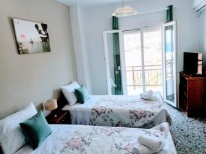 a bedroom with two beds and a window at Sunny Day Studios in Skala Marion