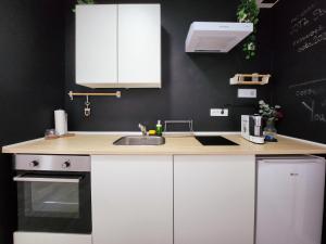 a kitchen with white cabinets and a sink at OOTA Soko with Parking Garage in Kragujevac +29 photos
