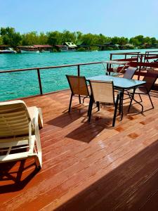a deck with tables and chairs on the water at Apartment Soreja in Ulcinj