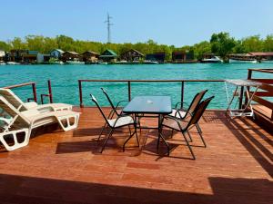 a table and chairs on a deck next to the water at Apartment Soreja in Ulcinj