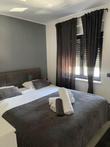a bedroom with two beds with pillows and a window at Rijeka Relax Apartment with parking in Rijeka