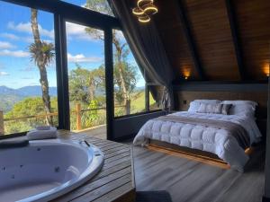 a bedroom with a large bed and a bath tub at Casa da Mata in São Bento do Sul +63 photos