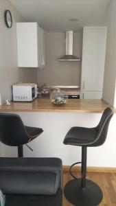 eine Küche mit zwei Stühlen vor einer Theke in der Unterkunft O Lar de Raxó in Raxo